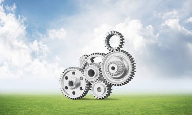 Yeşil çayır üzerinde dişli tekerlekler ile soyut mekanizma