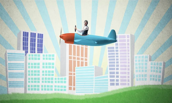 Man in aviator helmet sitting in propeller plane and flying above town. Pilot driving aeroplane on background of cartoon city. Cityscape with green grass and cute houses. Dreaming and imagination.