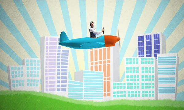 Man in aviator helmet sitting in propeller plane and flying above town. Pilot driving aeroplane on background of cartoon city. Cityscape with green grass and cute houses. Dreaming and imagination.