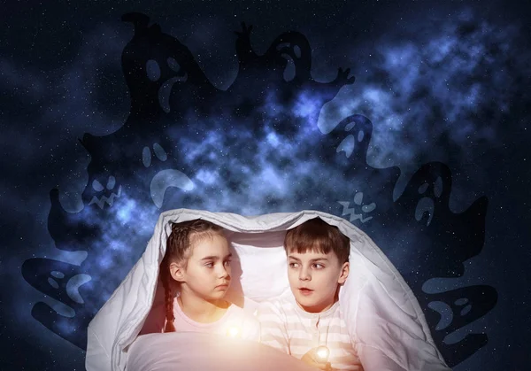 Scared sister and brother with flashlights hiding under blanket from nightmare monsters. Frightened preschool kids sitting in bed together. Children in pajamas and boo ghosts silhouettes above them.