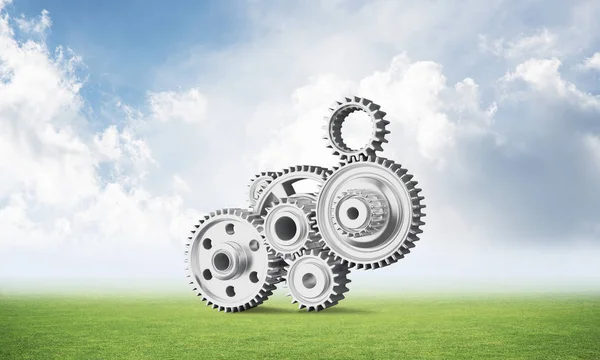 Yeşil çayır üzerinde dişli tekerlekler ile soyut mekanizma