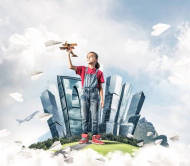 Şehrin yüzen adasında eski model uçaklarla oynayan tatlı bir kız.