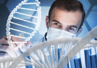 Klinik laboratuarında cam şişede reaksiyonları karıştıran genç bir bilim adamı.