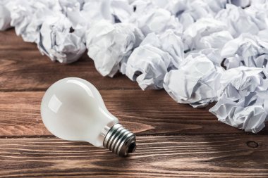 Ahşap masa üzerinde atık kağıt ampul ile ideolojik kavram