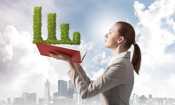 Mujer con planta verde en forma de gráfico financiero — Foto de Stock