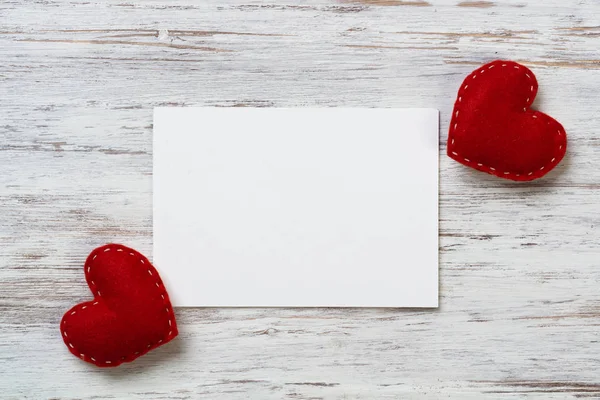 Blank sheet of paper and red love hearts