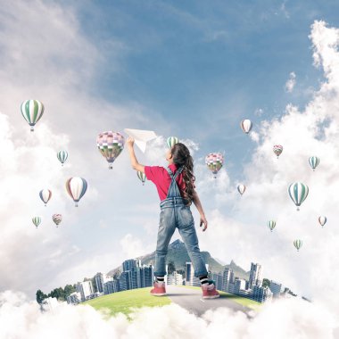 Yüzen adada kağıt uçak atan tatlı bir kız.