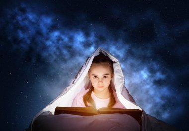 Küçük kız uyumadan önce yatakta sihirli hikayeler okuyor. Battaniyenin altında saklanan güzel bir çocuk. Kapalı çocuk geceleri uyuyamıyor. Derin mavi gökyüzü arka plan üzerinde pijama güzel kız Portresi
