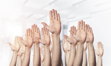 Oy verme jestini gösteren bir sıra adam eli. Katılım ve anlaşma işaretleri grubu. İnsan elleri, açık bulanık arka planda gesturing. Birçok kol birlikte kaldırdı ve mevcut popüler jest.