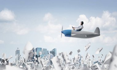 Havacı şapkalı işadamı ve şehir merkezinin üzerinde pervane lijör kullanan gözlük. Gökdelenlerin arka planına düşen kağıtlar. Komik adam küçük bir uçakta eğleniyor. Bulutlarla mavi gökyüzü.