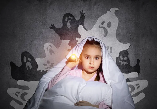 惊讶的女孩用手电筒躲在毯子下 惊讶的孩子坐在他的床上在家里 害怕黑暗 穿着睡衣的小孩晚上怕鬼 噩梦幻想和想象 — 图库照片
