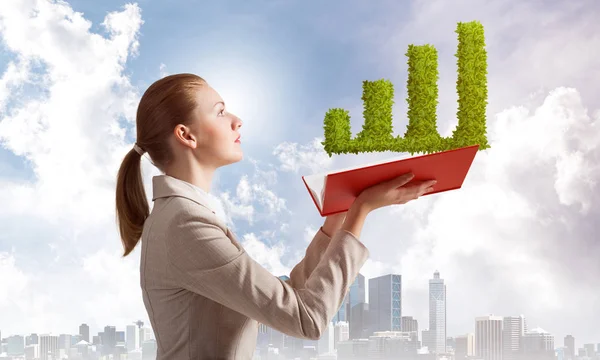 Mujer con planta verde en forma de gráfico financiero — Foto de Stock