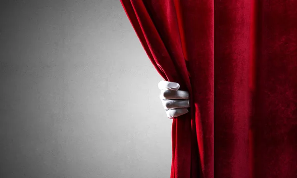 Concrete wall behind drapery curtain and hand opening it — Stock Photo, Image