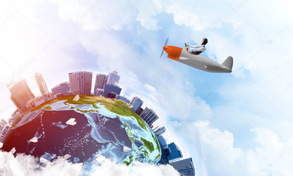 Man in aviator hat with goggles driving propeller plane. Earth globe with high modern buildings. Funny man having fun in small airplane. Blue cloudy sky with flying hot air balloons and paper planes