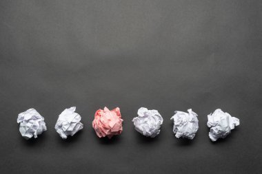 Beyaz toplar arasında buruşuk pembe kağıt top