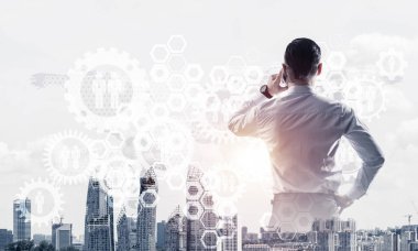 Zarif iş adamının arkası dönük ve cep telefonuyla konuşurken iki kez görüntülenmesi.