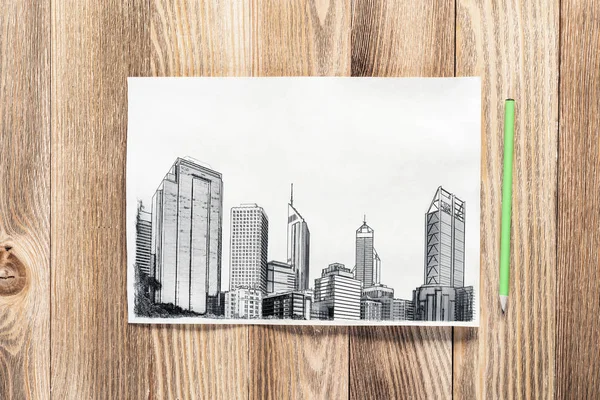 近代的な市内中心部の鉛筆描画 木製のテーブルの上にスケッチを描いた都市建築手 テクスチャーの自然な木製の背景に紙のシート アーキテクチャエージェンシーテンプレート コピースペースで上から見る — ストック写真