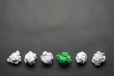 Beyaz topları arasında crumpled yeşil kağıt topu