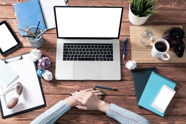 Kadın ellerini ahşap ofis masasında kavuşturmuş.