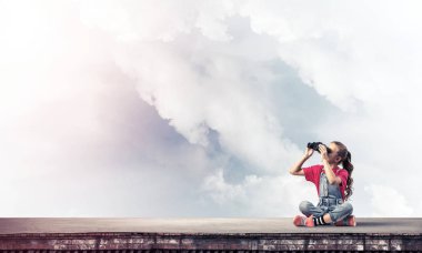 Dürbünle bakan, okul çağındaki sevimli kız çatıyı inşa ediyor.