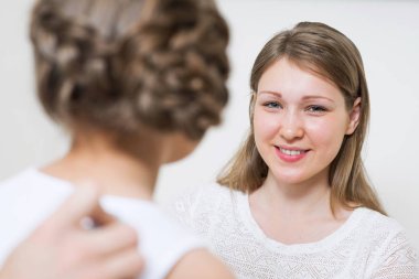 Çocuğu muayene eden doktor ve hastanede steteskopla akciğeri dinle. Küçük kızın tıbbi muayenesi. Gülümseyen genç anne ve küçük kız düzenli pediatrik muayenede. Aile Sağlık Merkezi