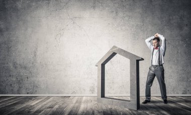 Taştan ev silueti, emlak sigortasının sembolü olarak boş odada.