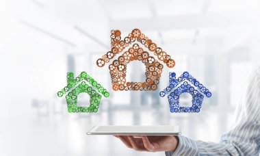 Ev simgesi tarafından tablet üzerinde sunulan emlak veya inşaat fikri