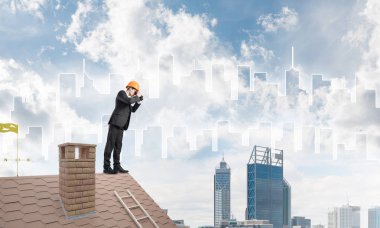 Takım elbiseli ve miğferli genç işadamı yeni bir şey arıyor. Karışık ortam