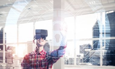 Giyen adam ekose desenli gömlek ve sanal kulaklık medya ekran Masası ile çalışma