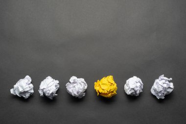 Beyaz toplar arasında buruşuk sarı kağıt top