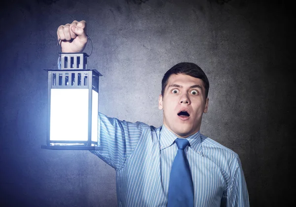 Homem de negócios horrorizado segurando lanterna brilhante — Fotografia de Stock