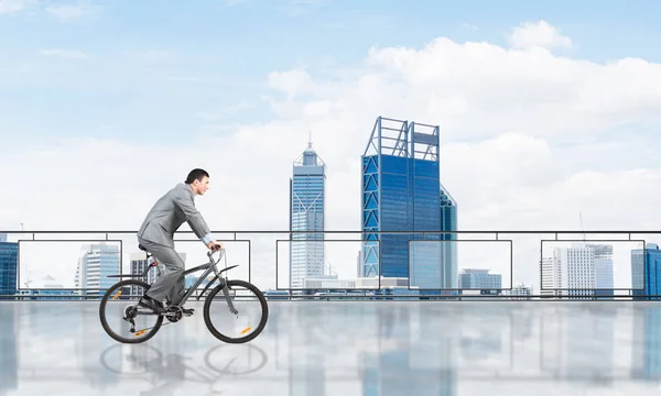 Mężczyzna jazda na rowerze na balkonie penthouse — Zdjęcie stockowe