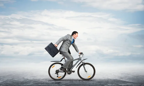 Mann im Business-Anzug fährt Fahrrad im Freien. — Stockfoto