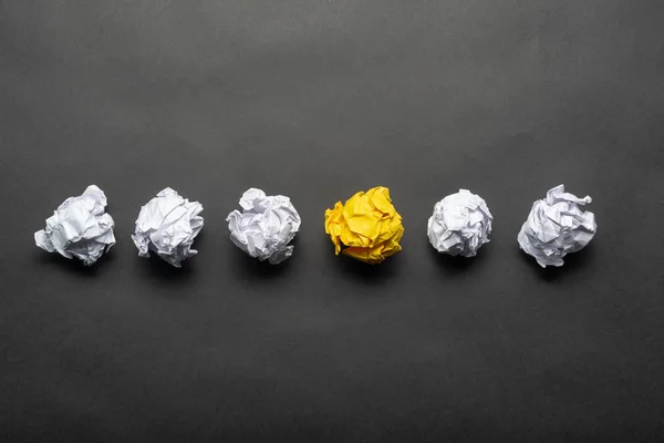 Crumpled żółta kula papieru wśród białych kulek — Zdjęcie stockowe