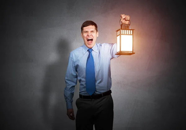 Homem de negócios gritando segurando lanterna brilhante — Fotografia de Stock