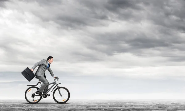 Mann im Business-Anzug fährt Fahrrad im Freien. — Stockfoto