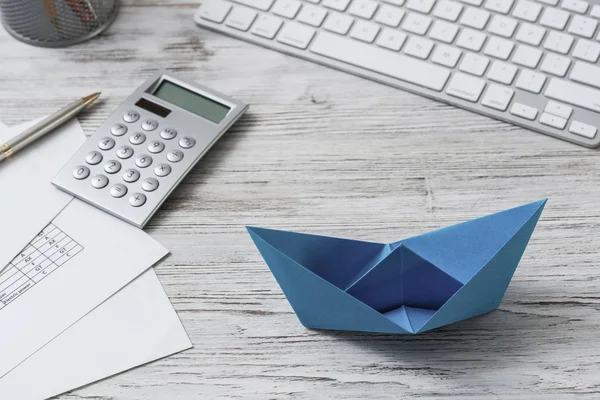 Espaço de trabalho de escritório moderno com navio de papel azul — Fotografia de Stock