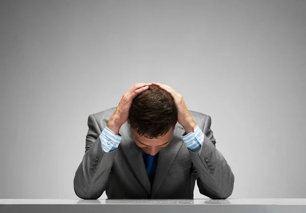 Frustrierter Mann Sitzt Mit Den Händen Auf Dem Kopf Schreibtisch — Stockfoto