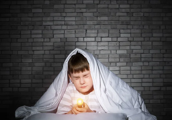 恐惧的孩子，毛毯下有手电筒 — 图库照片