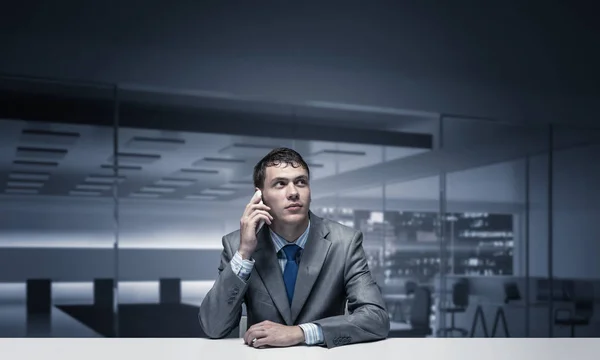 年轻人在会议室里打电话 商人坐在办公室内部的办公桌前 男人的肖像穿着西装和领带 使用智能手机进行对话的商务人士 — 图库照片