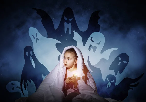 Scared girl with flashlight hiding under blanket from imaginary phantoms. Frightened kid sitting in bed on night sky background. Night terrors of child. Girl in pajamas and boo ghosts silhouettes