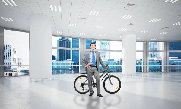 Χαμογελαστός Άντρας Στο Επιχειρηματικό Κοστούμι Στέκεται Ποδήλατο Στην Άνετη Αίθουσα — Φωτογραφία Αρχείου