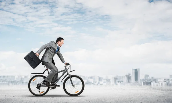 Mann im Business-Anzug fährt Fahrrad im Freien. — Stockfoto