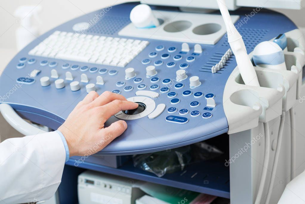 Sonographer using ultrasound machine at work.