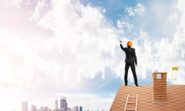 Erkek mimar mavi gökyüzüne modern şehrin siluetini çizer. Karışık ortam