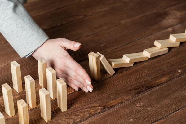 Geschäftsfrau schützt Dominosteine vor dem Sturz — Stockfoto