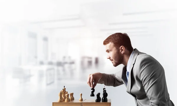 Концентрированный бизнесмен играет в шахматы — стоковое фото