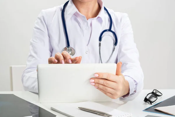 Chiudi le mani del medico femminile usando il tablet — Foto Stock