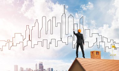 Erkek mimar mavi gökyüzüne modern şehrin siluetini çizer. Karışık ortam