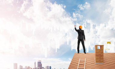 Erkek mimar mavi gökyüzüne modern şehrin siluetini çizer. Karışık ortam